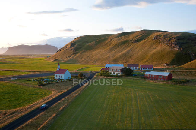 Church and small group of houses with car on road near Vik — Stock Photo