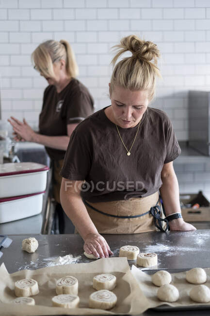 Mujer trabajando en una cocina, preparando masa de pasteles daneses. - foto de stock