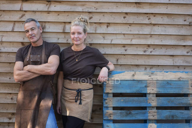 Мужчина и женщина в фартуках, коллеги отдыхают от работы, смеются — стоковое фото