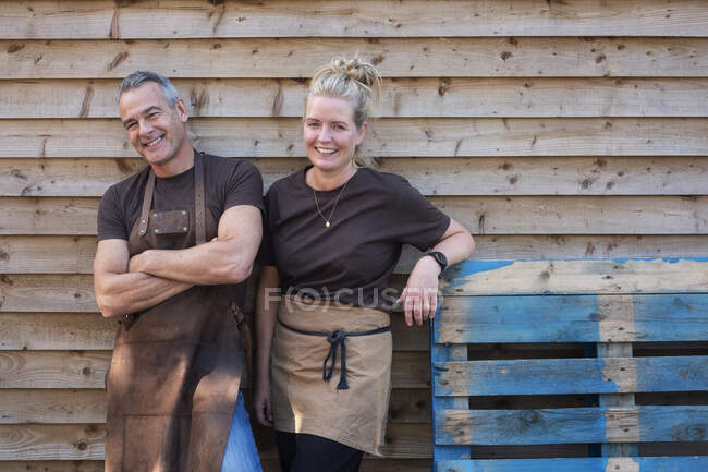 Uomo e donna in grembiuli, colleghi che si prendono una pausa dal lavoro, ridono — Foto stock