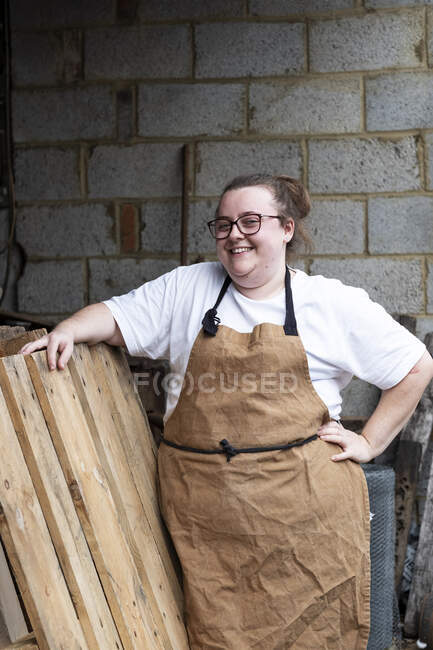 Portrait of female baker outdoors, hand on hip, smiling at camera. — Stock Photo