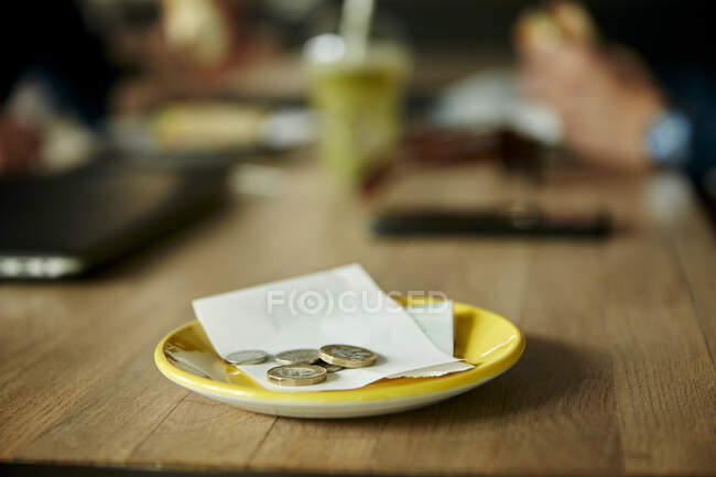 Coins and bill on restaurant table, close-up — Stock Photo