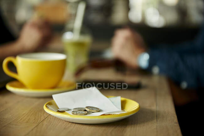 Moedas e conta na mesa do restaurante, close-up — Fotografia de Stock