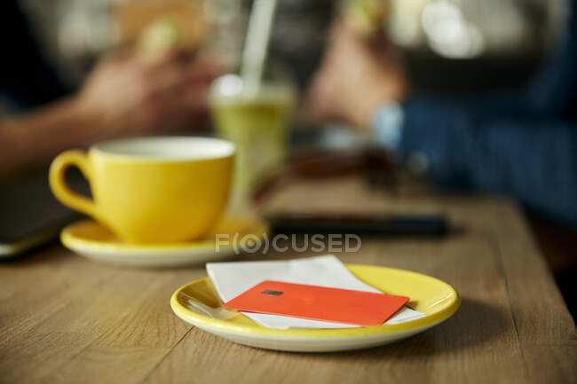 Tarjeta de crédito y factura en la mesa de café, vista de primer plano - foto de stock