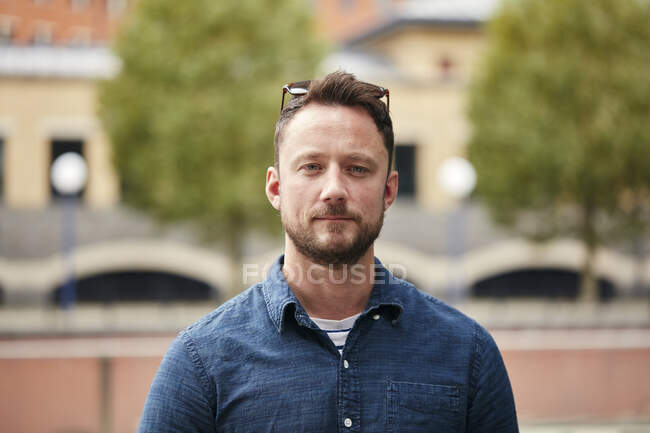 Uomo con la barba in piedi all'aperto in una città in una strada tranquilla — Foto stock