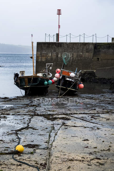 Vue en angle élevé des bateaux de pêche amarrés au port à marée basse. — Photo de stock
