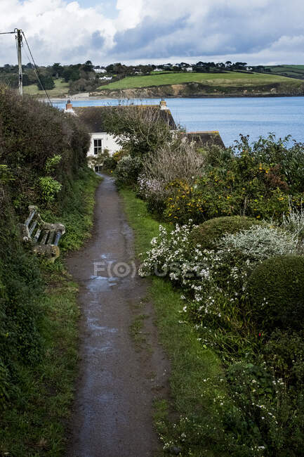 Vista de ângulo alto ao longo de um caminho lamacento para uma casa de campo costeira. — Fotografia de Stock