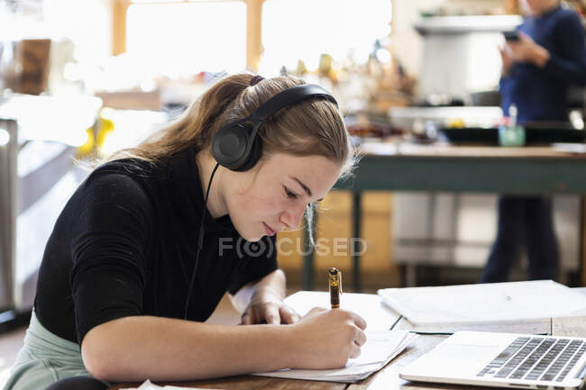 Adolescente usando fones de ouvido, desenho em papel — Fotografia de Stock