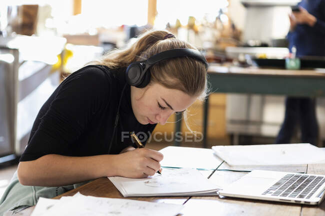 Adolescente con le cuffie, disegno su carta — Foto stock
