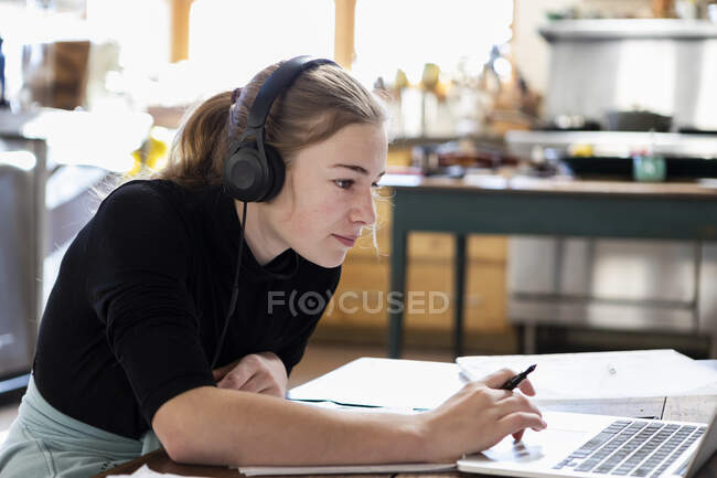 Adolescente con auriculares, dibujo sobre papel - foto de stock