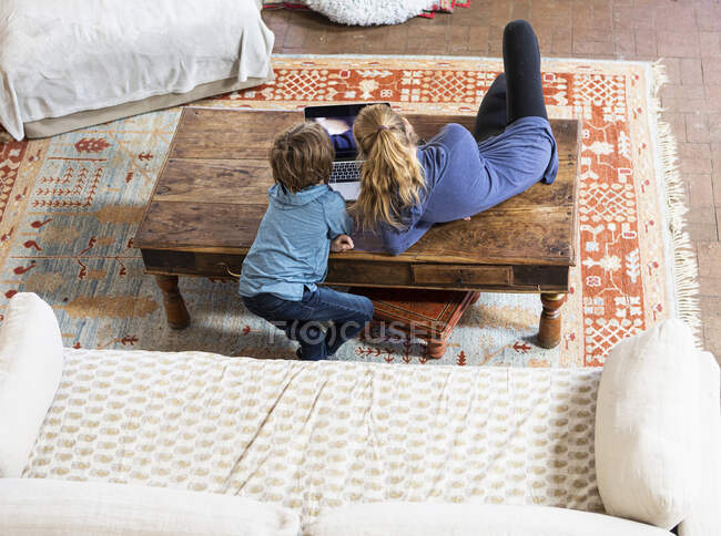 Teenage girl and her younger brother looking at a laptop screen — Stock Photo