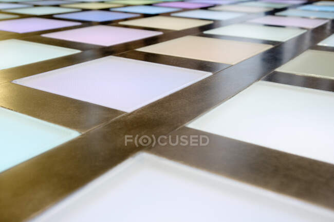 Close-up of illuminated multicoloured tiled dance floor, disco lighting. — Stock Photo