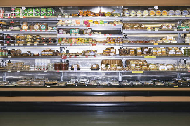 Open refridgerator stocked with food in supermarket. — Stock Photo