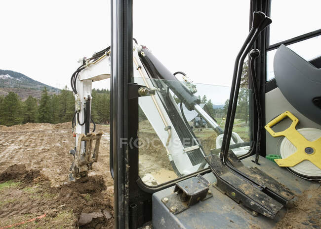Escavador mecânico escavando chão no ambiente rural. — Fotografia de Stock