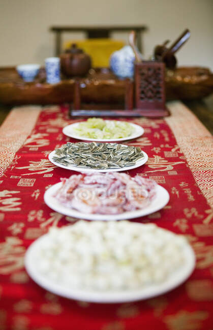 Primer plano de platos de aperitivos con juego de té en la mesa. - foto de stock