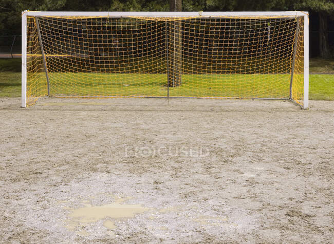 Tornetz auf matschigem Fußballplatz. — Stockfoto