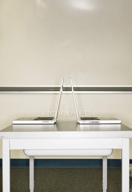 Dos portátiles abiertos en una mesa. - foto de stock
