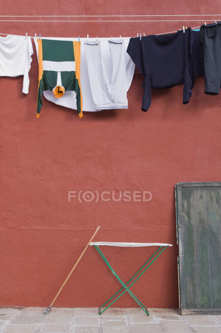 Roupas penduradas na linha de lavanderia na parede. — Fotografia de Stock