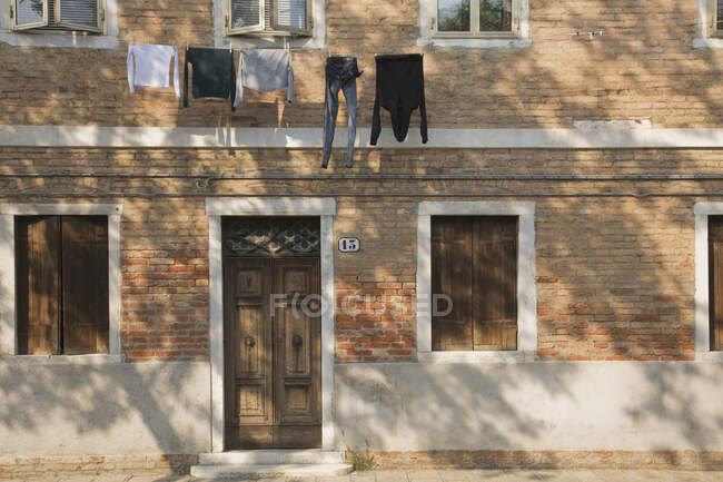 Ligne de lavage avec buanderie suspendue à l'extérieur du bâtiment en brique. — Photo de stock