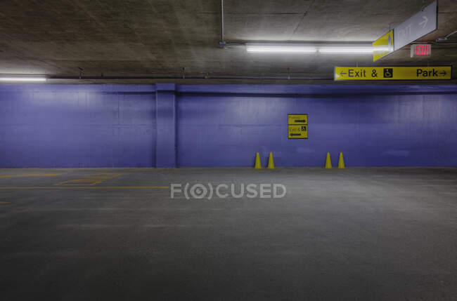 Estacionamiento subterráneo con conos de tráfico y pared azul. - foto de stock