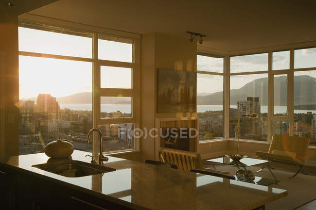 Puesta de sol a través de ventanas de apartamento de planta abierta. - foto de stock