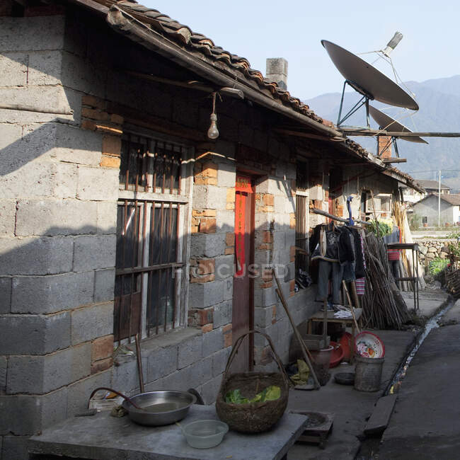 Exterior of village houses at sunset a rural area with large satellite dishes — Stock Photo
