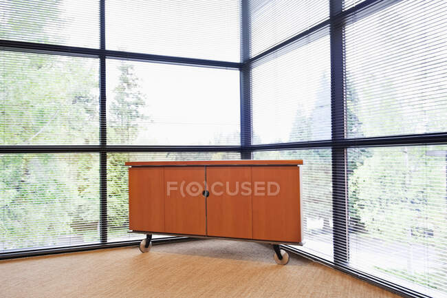 Storage cabinet in a corner office with floor to ceiling glass walls — Stock Photo