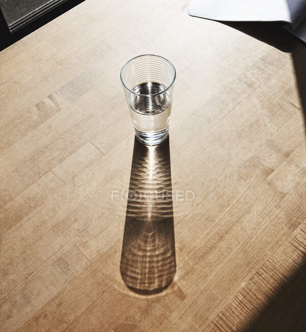 Vaso de agua potable sobre superficie de madera - foto de stock