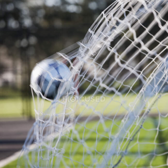 Pallone da calcio che colpisce il retro di una rete da calcio. — Foto stock