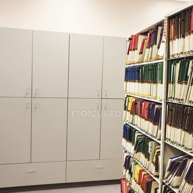 Bookshelves with files and cabinets in office, analogue record storage. — Stock Photo