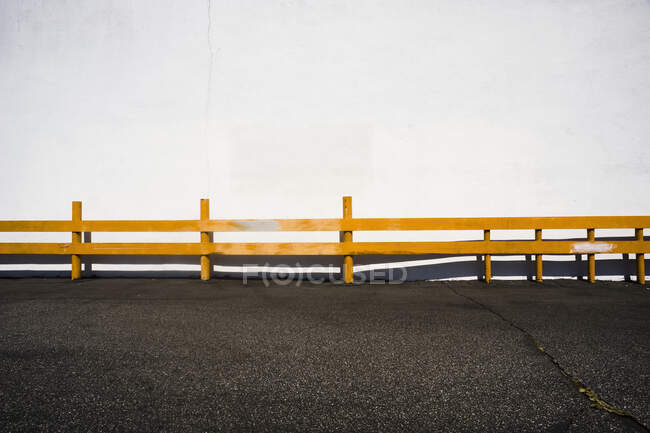 Uma superfície de estrada e uma cerca amarela. — Fotografia de Stock