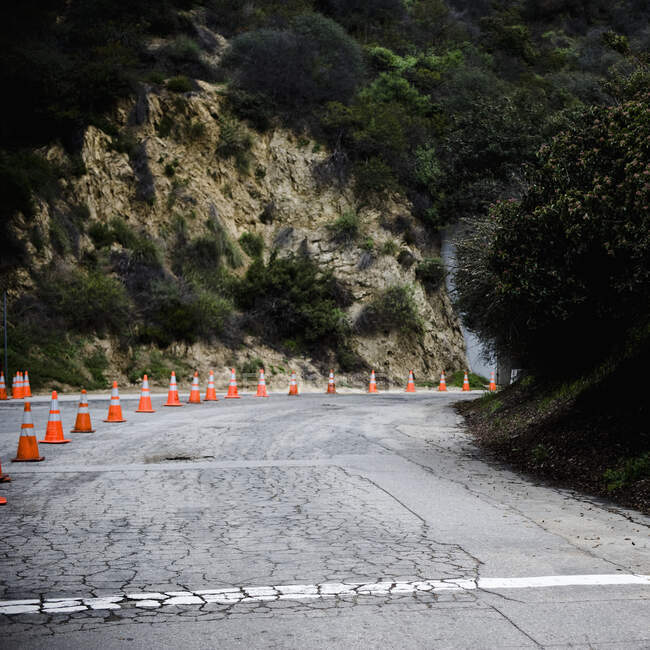 Cones na estrada rural com asfalto rachado. — Fotografia de Stock