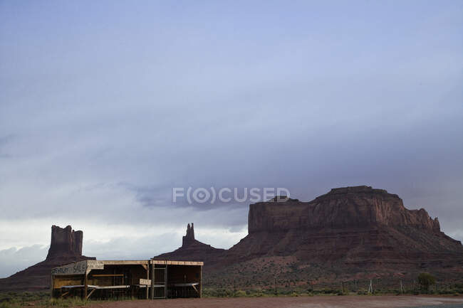 Formazione rocciosa in campagna con capannone in primo piano. — Foto stock