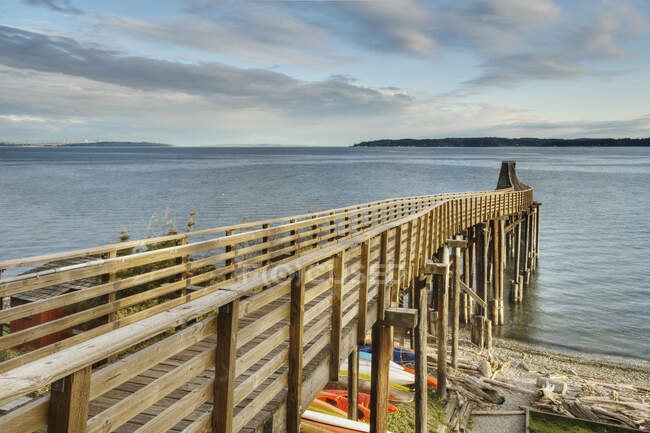 Passerella in legno sulla spiaggia fino all'acqua. — Foto stock