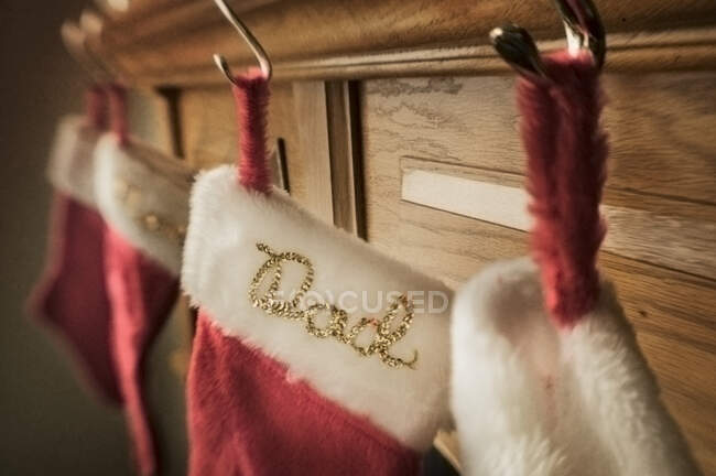 Weihnachtsstrümpfe hängen an einem Kaminsims. Bestickter Name Papa — Stockfoto