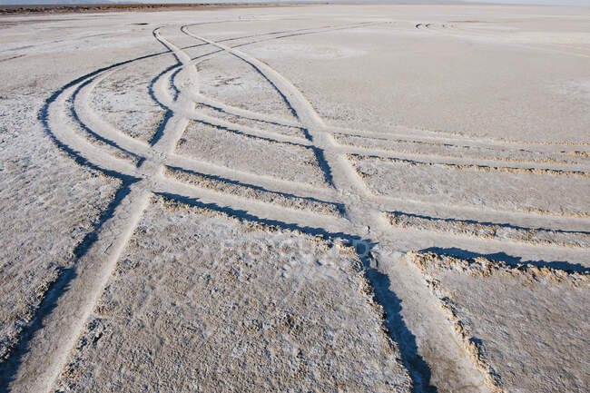 Elevado cumes e linhas, marcas de pneus em uma superfície deserto. — Fotografia de Stock