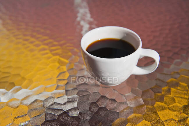 Cup of black coffee on glass table. — Stock Photo