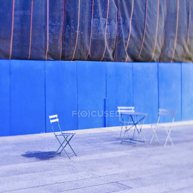 Folding chairs in front of construction site hoarding. — Stock Photo