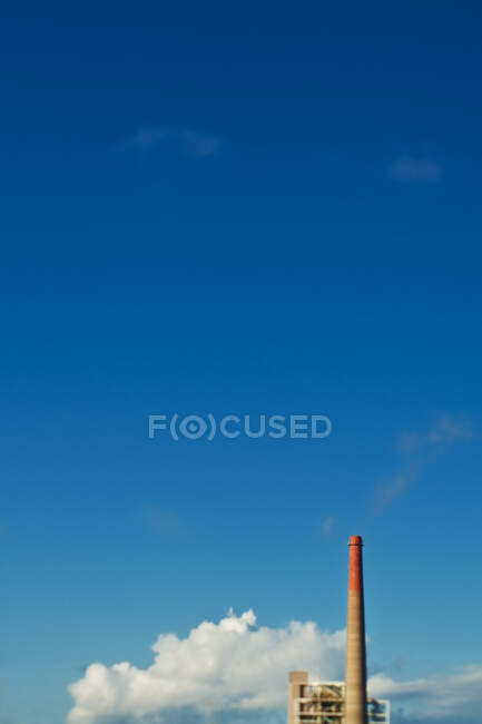 Промисловий димохід на тлі блакитного неба — стокове фото