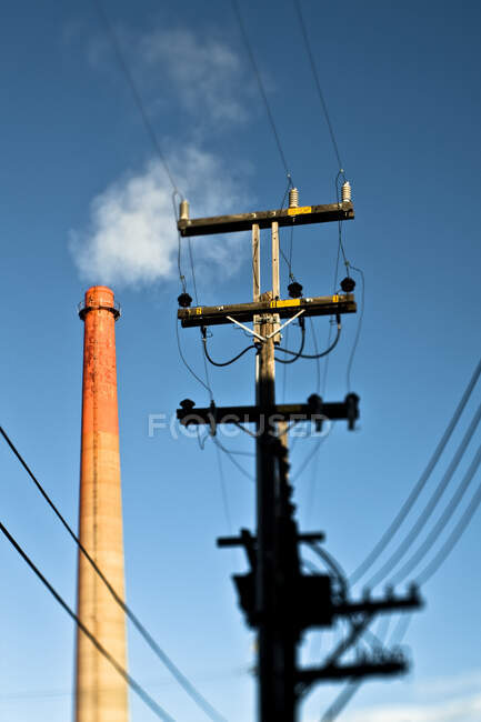 Линия электропередач с промышленным дымоходом — стоковое фото