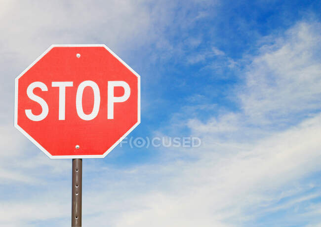 Señal roja de stop al lado de una carretera - foto de stock