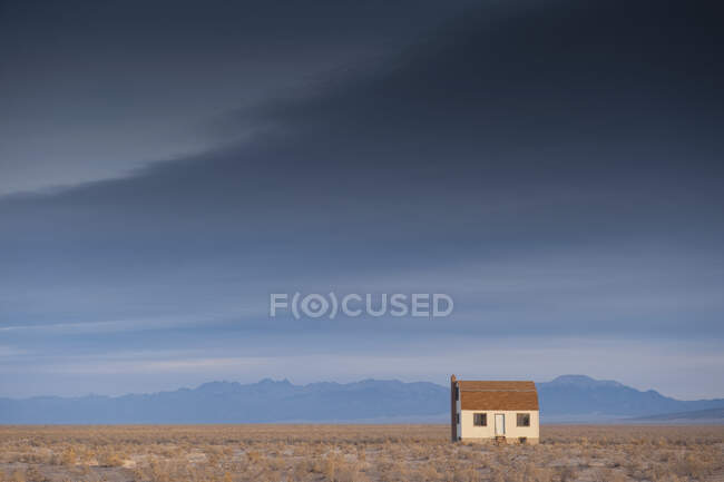 Cottage em uma paisagem rural com montanha atrás. — Fotografia de Stock