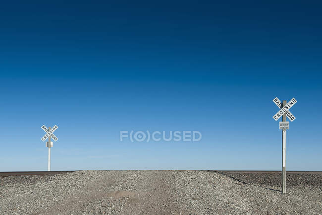 Sinais de travessia ferroviária na paisagem do deserto. — Fotografia de Stock