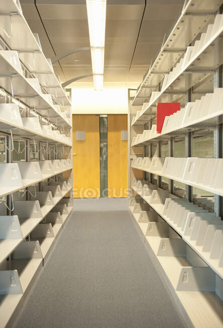 Prateleiras de biblioteca vazias com um livro vermelho. — Fotografia de Stock