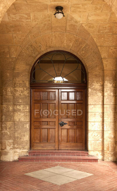 Деревянная дверь в каменной арке. — стоковое фото