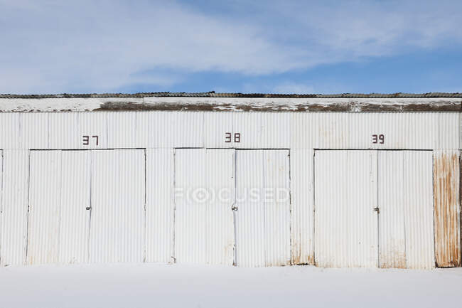 Porte numerate su un edificio di stoccaggio in metallo ondulato. — Foto stock