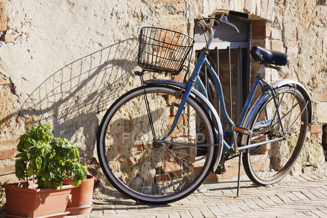 Велосипед опирается на стену каменного дома. — стоковое фото