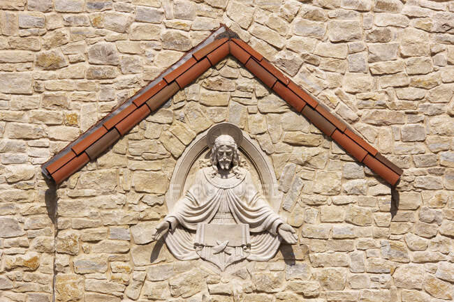 Скульптура Иисуса возведена в каменную стену. — стоковое фото