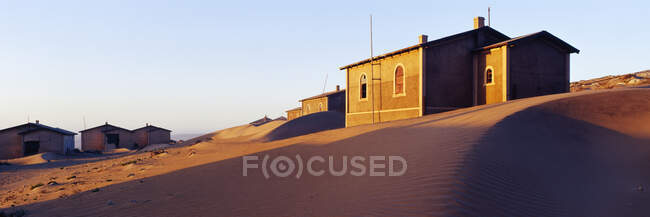 Casas enterradas en arena en pueblo desierto. - foto de stock