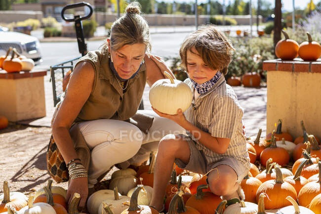 Mutter und ihr kleiner Sohn im Kürbispflaster. — Stockfoto